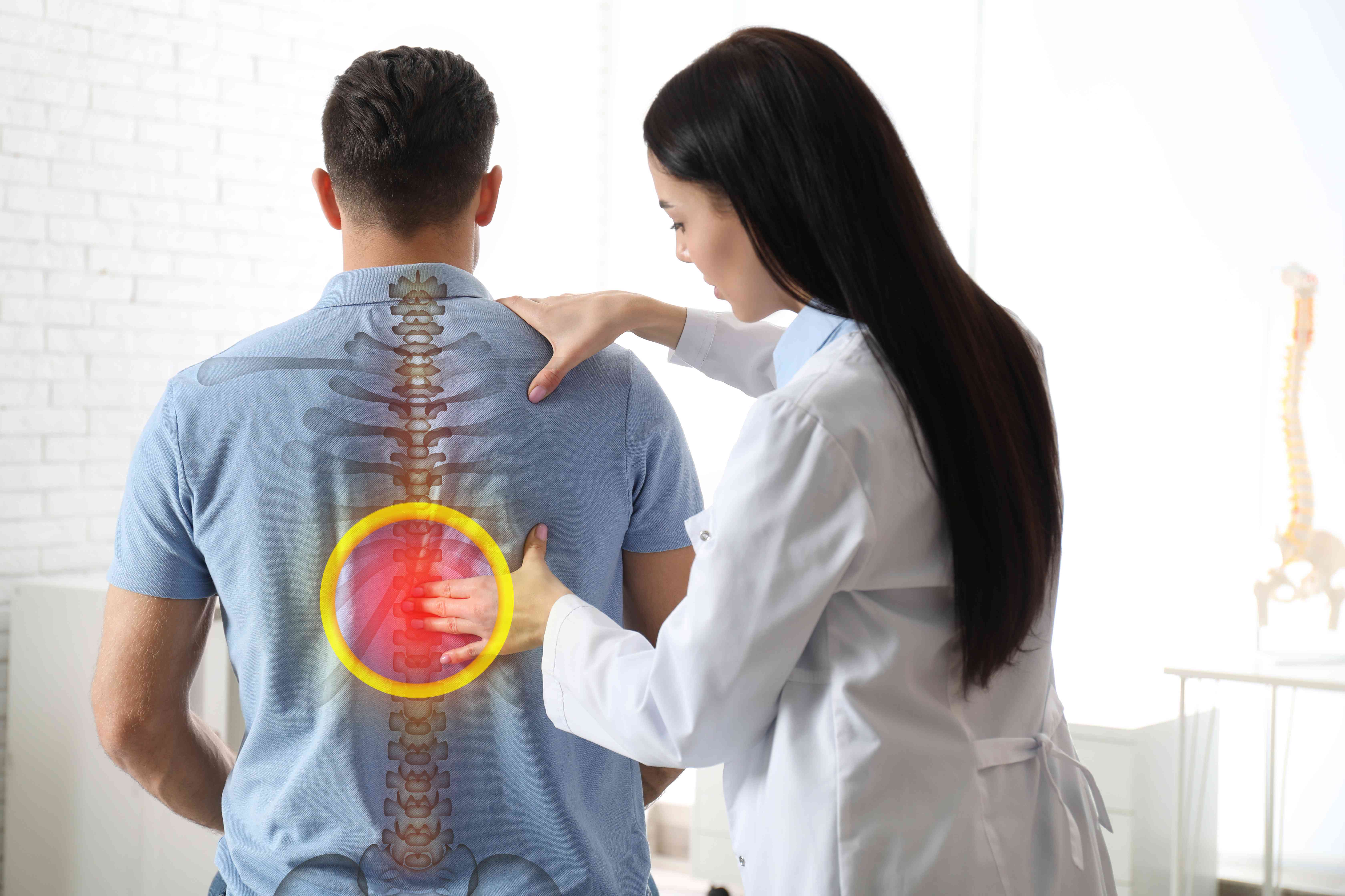 professional-orthopedist-examining-man-medical-office-spinal-pain-compressed