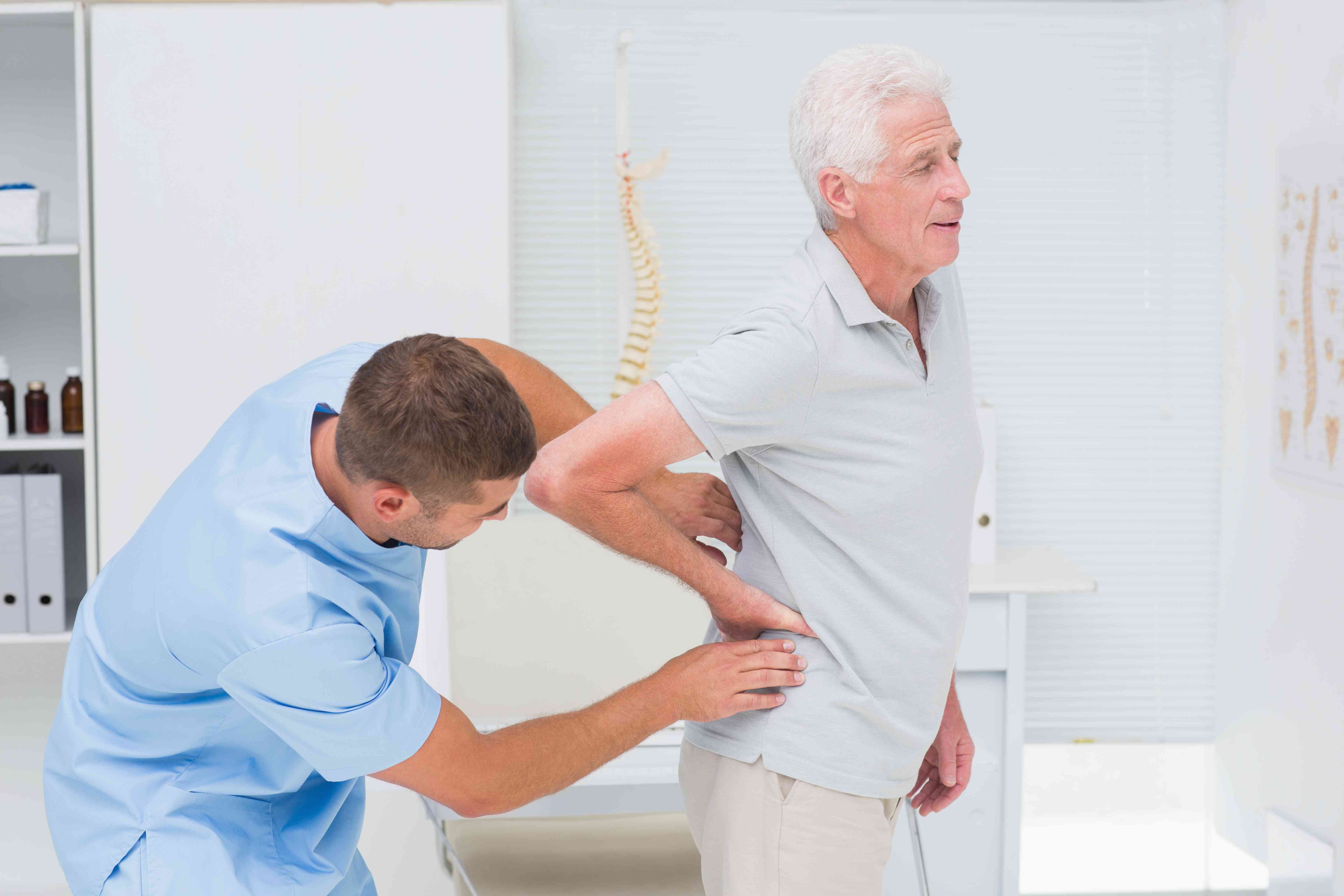 physiotherapist-giving-back-massage-senior-man-compressed