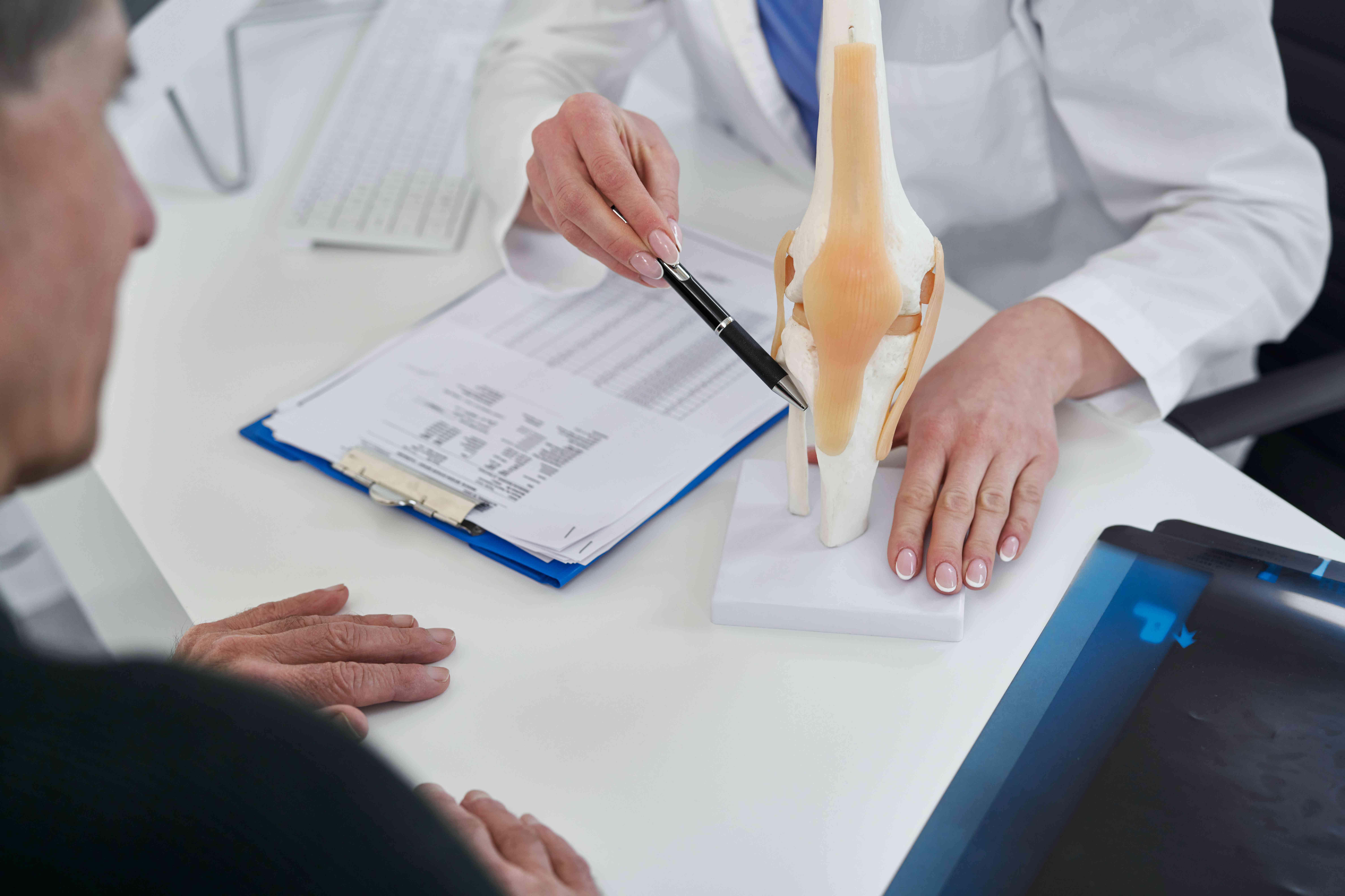 midsection-doctor-explaining-bone-structure-patient-hospital-compressed